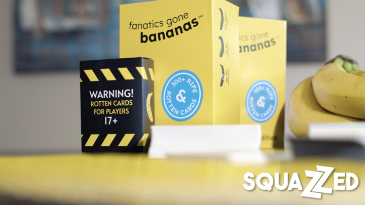 A close-shot photo of Fanatics Gone Bananas, including the rotten box, decks of cards, cards fanned out, and a bunch of bananas on a table. Features the Squazzed logo.