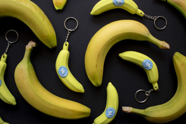 An assortment of banana keychains and real bananas.