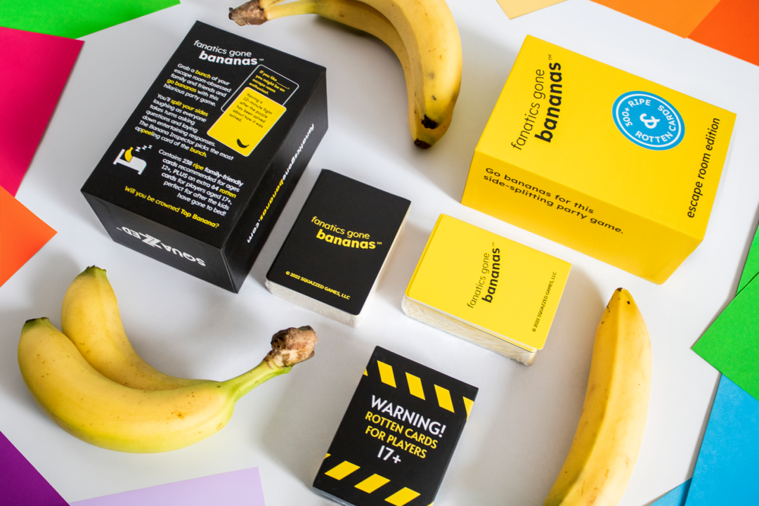 Fanatics Gone Bananas Box Flat Lay Paper A flat lay style photograph of the Fanatics Gone Bananas box and contents, surrounded by bananas and colored paper cut outs.