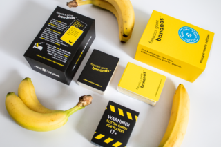 A flat lay style photograph of the Fanatics Gone Bananas box and contents, surrounded by bananas.