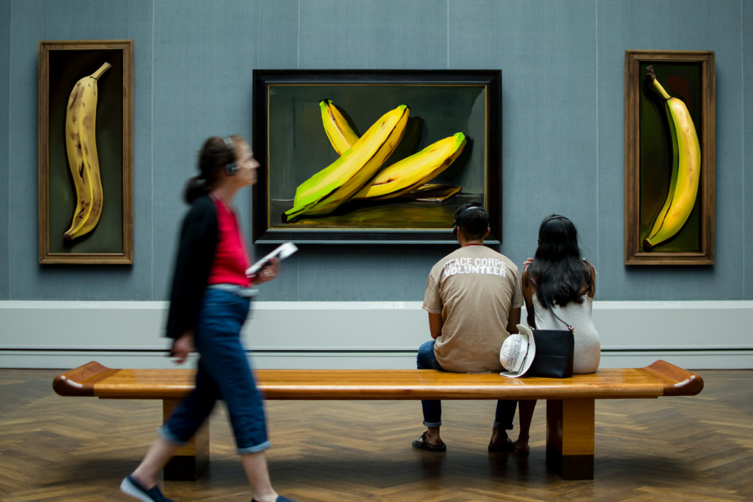 Three people observe thought-provoking art pieces.