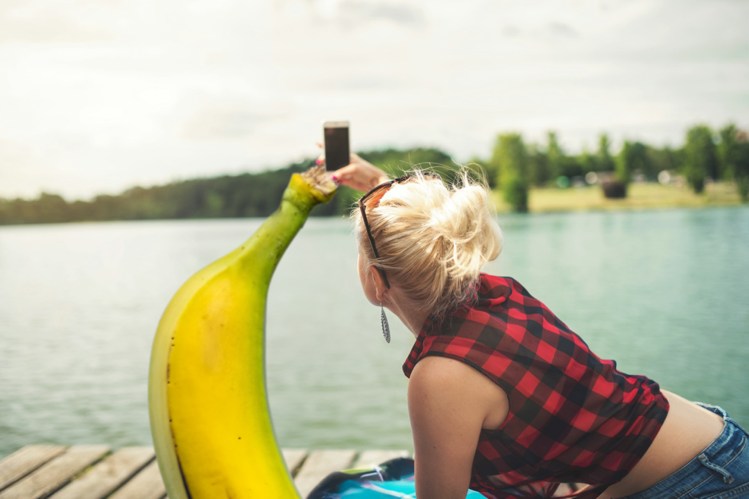 A couple take a selfie together by the lake.