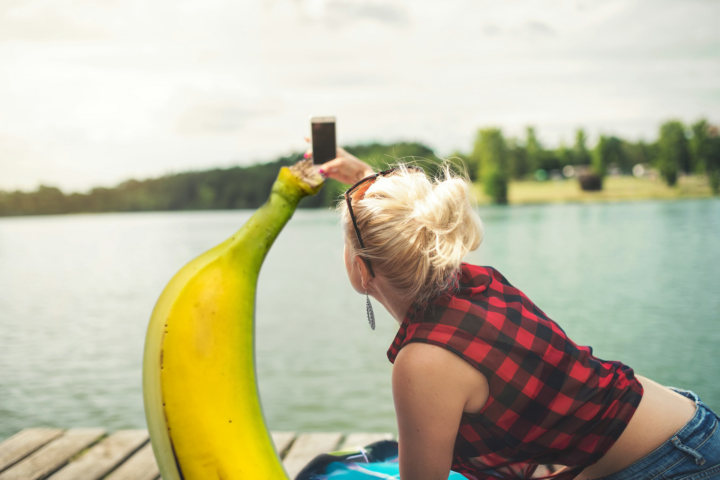 A couple take a selfie together by the lake.