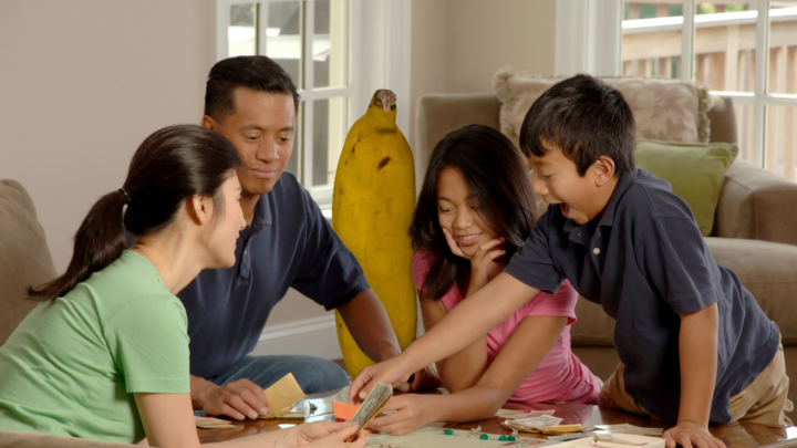 A family gather round to play a party game.