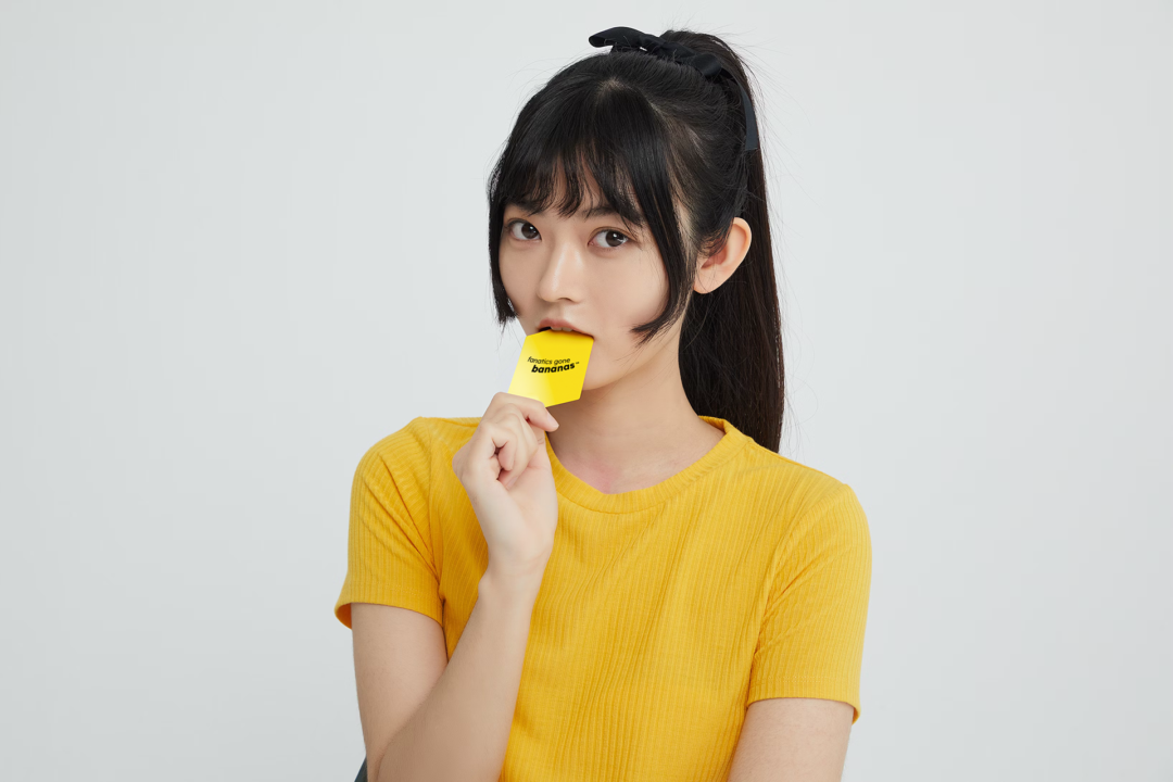 A lady takes a taste of a Fanatics Gone Bananas card.