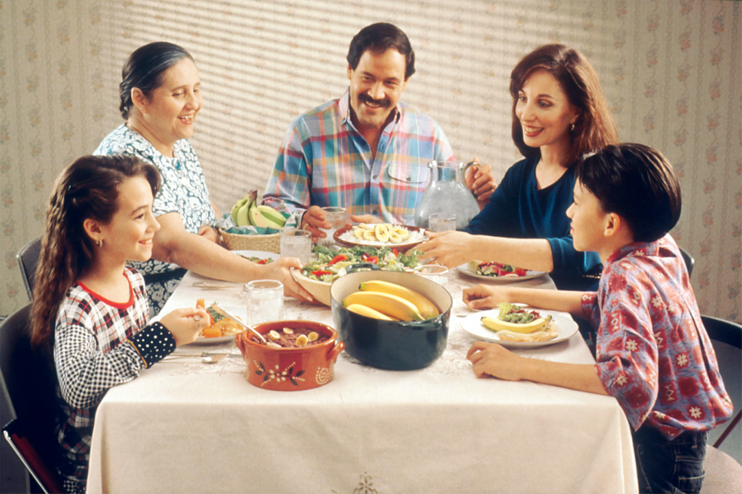 Wholesome Family Time A family around the dinner table consuming banana based meals.