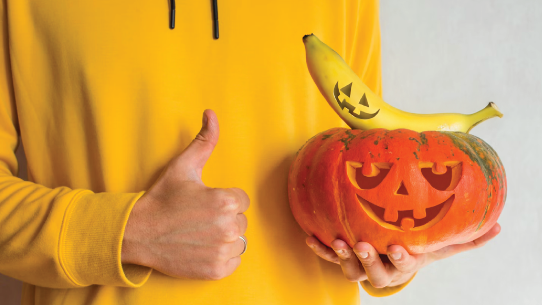 A carved pumpkin and banana for halloween.